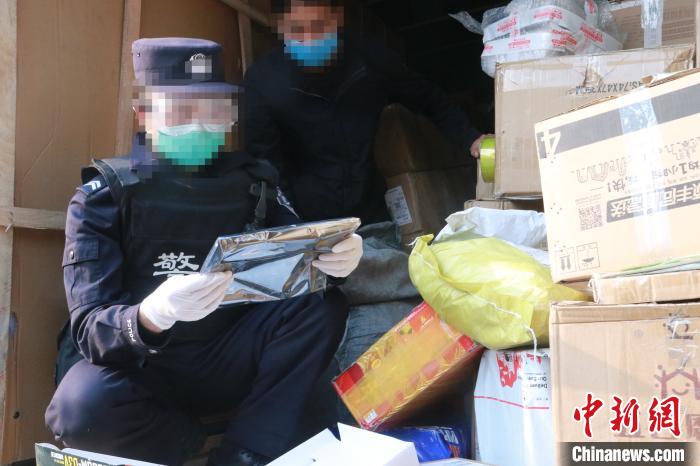 圖為勐康邊檢站民警在對(duì)快遞運(yùn)輸車輛進(jìn)行例行檢查?！钐?攝