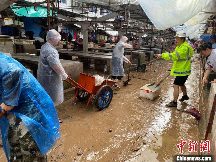 圖為7月26日，暴雨引發(fā)的洪水過境后，重慶萬州區(qū)分水鎮(zhèn)政府干部職工及志愿者清掃淤泥和垃圾?！　≈貞c萬州區(qū)委宣傳部供圖 攝